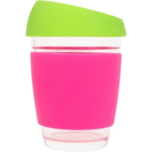 A reusable glass coffee cup in pink with a green lid and a silicone grip. It features a logo on the side.
