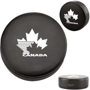 A black hockey puck shape stress reliever featuring a white maple leaf design and a logo.