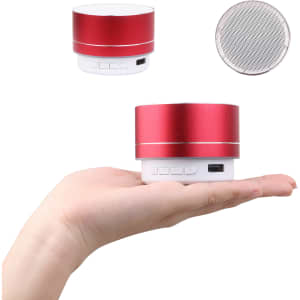 A red metal Bluetooth speaker held in a hand, featuring buttons and a logo on the base.