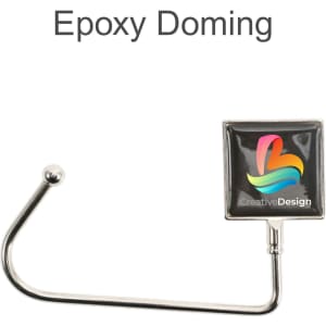 A square silver desk hook with a coloured epoxy domed logo attached at the top.