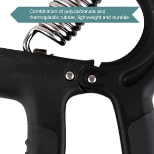 A close-up of a black adjustable hand grip made from polycarbonate and thermoplastic rubber with a spring mechanism.