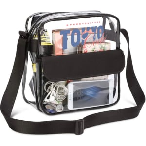 A clear shoulder crossbody bag filled with magazines, a phone, headphones, and various small items, featuring a black strap.