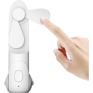A white handheld mini fan with a flashlight, featuring two blades and a button on the body. A hand is touching the fan.