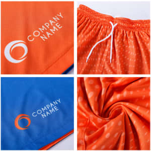 Reversible basketball shorts featuring orange and blue designs, with a logo displayed on each side and a drawstring.