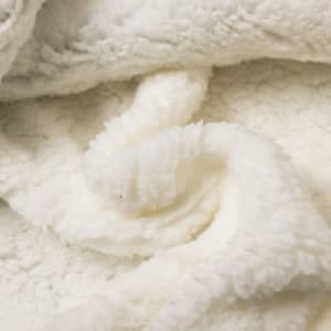 A soft, cream-coloured wearable blanket made from 100% polyester with a plush, textured surface and folds.