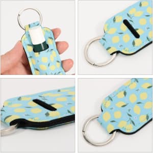A neoprene lipstick bag featuring a blue background with yellow lemon patterns and a silver keyring attachment.