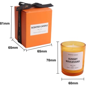 A 3.5oz orange glass candle with a white label and a black ribbon on a matching box.