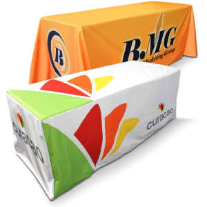 Two fitted tablecloths displayed, one in vibrant orange with a logo and the other in white with a multi-coloured design.