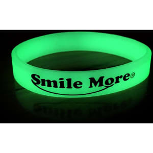 A green glow in the dark wristband with a logo, displayed against a dark background.