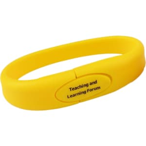 A yellow silicone wristband flash drive with a smooth surface and a central logo area.