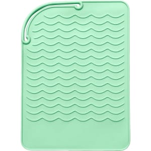 A mint green silicone pad featuring a wavy texture and a loop for hanging. It has a branding logo.