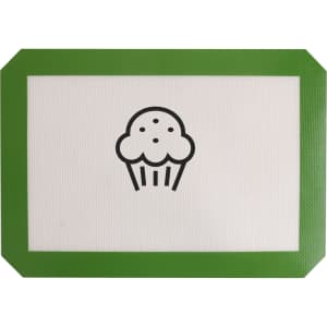 A silicone baking mat with a white surface and a green border featuring a cupcake design in the centre.