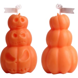 Triple pumpkin-shaped candles in vibrant orange with carved faces, featuring a playful design.