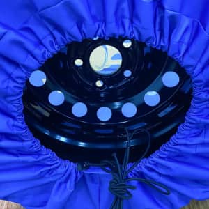 A blue spare tyre cover with a black inner section and circular cutouts, featuring a drawstring for fastening.