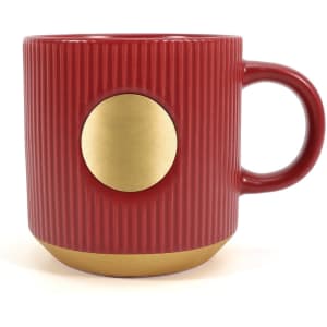A red ceramic coffee mug featuring a bronze medal design and ribbed texture, with a curved handle.
