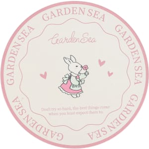 A round PU coaster featuring a pink and cream design with a cute bunny illustration and a logo.