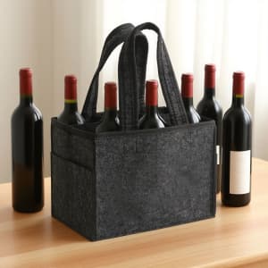 A felt wine tote bag in grey holds several bottles of red wine, with sturdy handles and pockets on the sides.