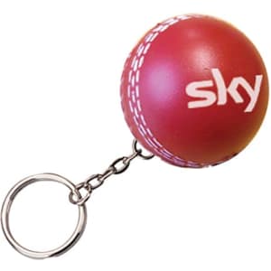 A red cricket ball stress reliever attached to a keyring, featuring a white logo.