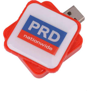 A square red flash drive with a white top featuring a logo. The drive has a USB connector.