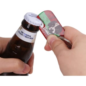 A drink bottle with a blue and white cap being opened by a red, green, and silver dog tag bottle opener keyring.