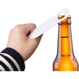 A drink bottle opener in hand, designed with a sleek, white appearance, positioned above a brown beer bottle.