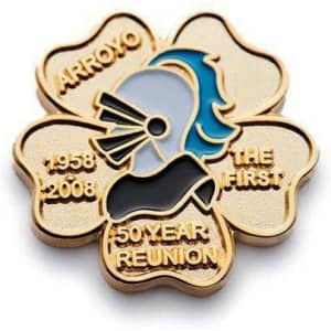 A gold embossed soft enamel pin featuring a stylised profile, set in a flower shape with inscriptions.