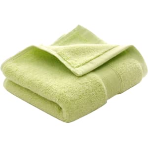 A folded embroidered cotton hand towel in a soft lime green shade, featuring a textured finish and a logo.