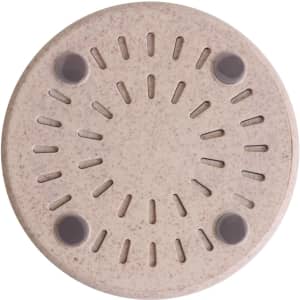 A round, beige wireless charger with textured surface and four non-slip pads on the bottom. Features a logo.