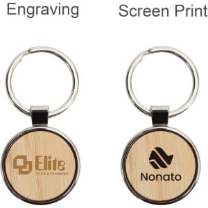 A round wooden keyring featuring a metallic rim, displaying engraved logos on a bamboo surface.
