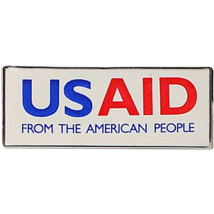 A rectangular lapel pin in blue, red, and white colours featuring a logo and text.