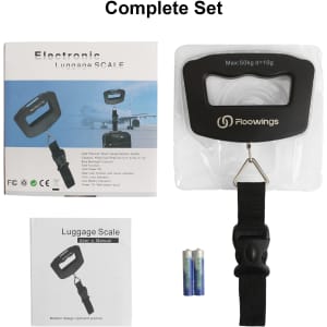 A black electronic luggage scale with a carrying strap, batteries, and a user manual, presented in a complete set.