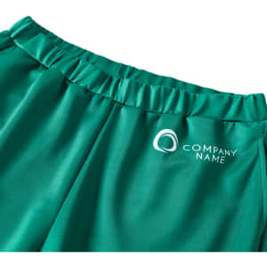 A pair of green unisex adult sports shorts made of 100% polyester featuring a logo.