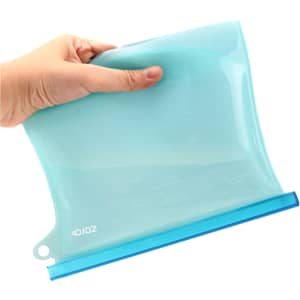 A silicone reusable storage pouch in a light blue colour, held by a hand, displaying its flexible design.