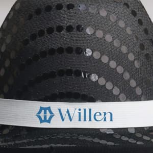 A black sequin cowboy hat with a silver band featuring a logo.