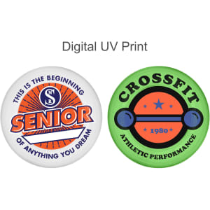 Two circular promotional pins featuring vibrant designs, one in orange and blue, the other in green and black. Each pin has a logo.