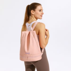A pink backpack with a handle and adjustable straps, featuring a logo on the front.