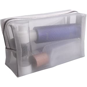 A transparent nylon mesh cosmetic bag containing various skincare and cosmetic products in multiple shades.