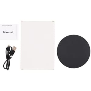 A round black wireless charger with a USB cable and a manual, all placed on a white background.