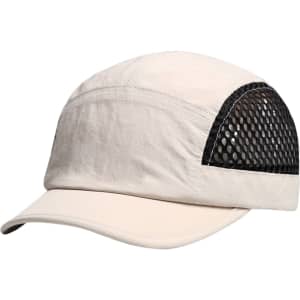 A short brimmed mesh running cap in cream and black, featuring a mesh panel and a rounded brim.