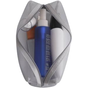 A grey nylon mesh cosmetic bag with various beauty products, including a blue spray bottle and a white container.
