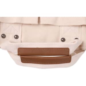 A beige canvas tote bag with brown leather straps and metal studs, featuring a simple design and sturdy construction.