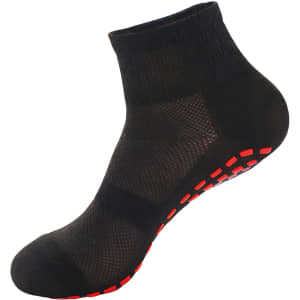 A pair of black crew socks with a red dotted sole and a mesh design. The socks also feature a logo.