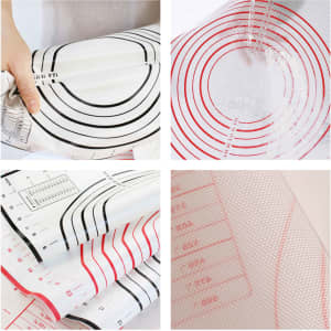 A silicone pastry mat with red and black measurement markings, featuring a grid pattern and a textured surface.