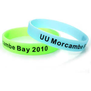 A set of glow-in-the-dark silicon wristbands in green and blue, featuring a logo and text.