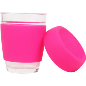 A reusable glass coffee cup with a transparent glass body and a bright pink silicone sleeve.
