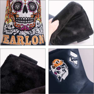 A decorative black putter cover featuring colourful skull designs and a soft interior lining, with branding present.
