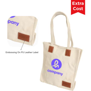 A cream canvas bag with a magnetic snap and a branded PU leather label. It has tan straps and accents.