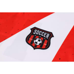 A red and white football jersey featuring a logo with a soccer ball and stripes.