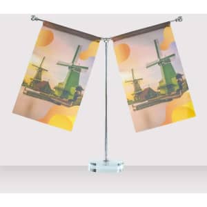A desk flag display featuring two flags with a windmill design, mounted on a silver pole with a circular base.