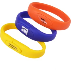 Three oval silicone wristband flash drives in orange, blue, and yellow, featuring logos on their surfaces.
